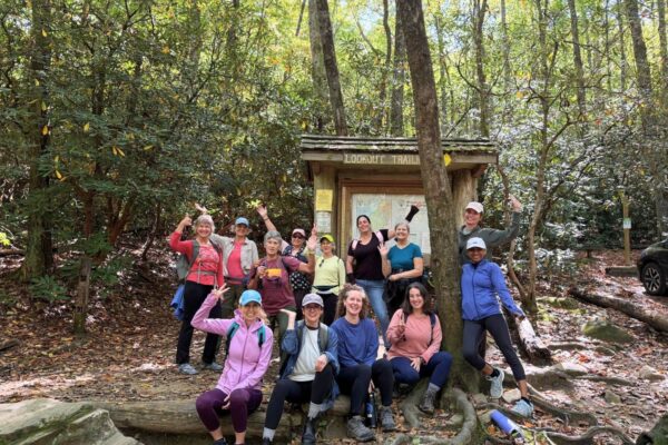 laughing women at trailhead during women's yoga retreat near asheville