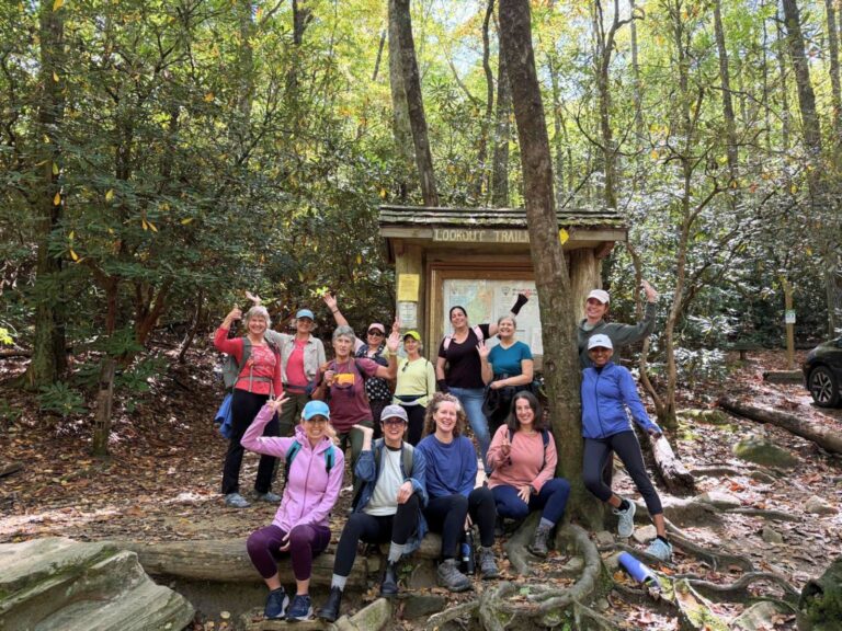 laughing women at trailhead during women's yoga retreat near asheville